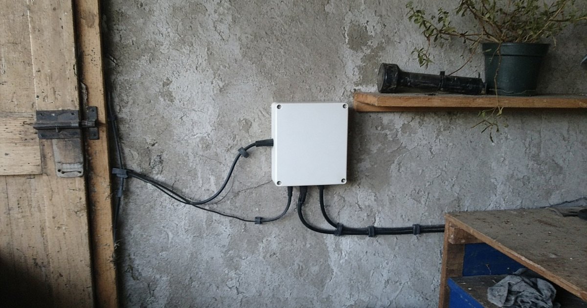 A solar inverter mounted on a garage wall with ordinary cable runs