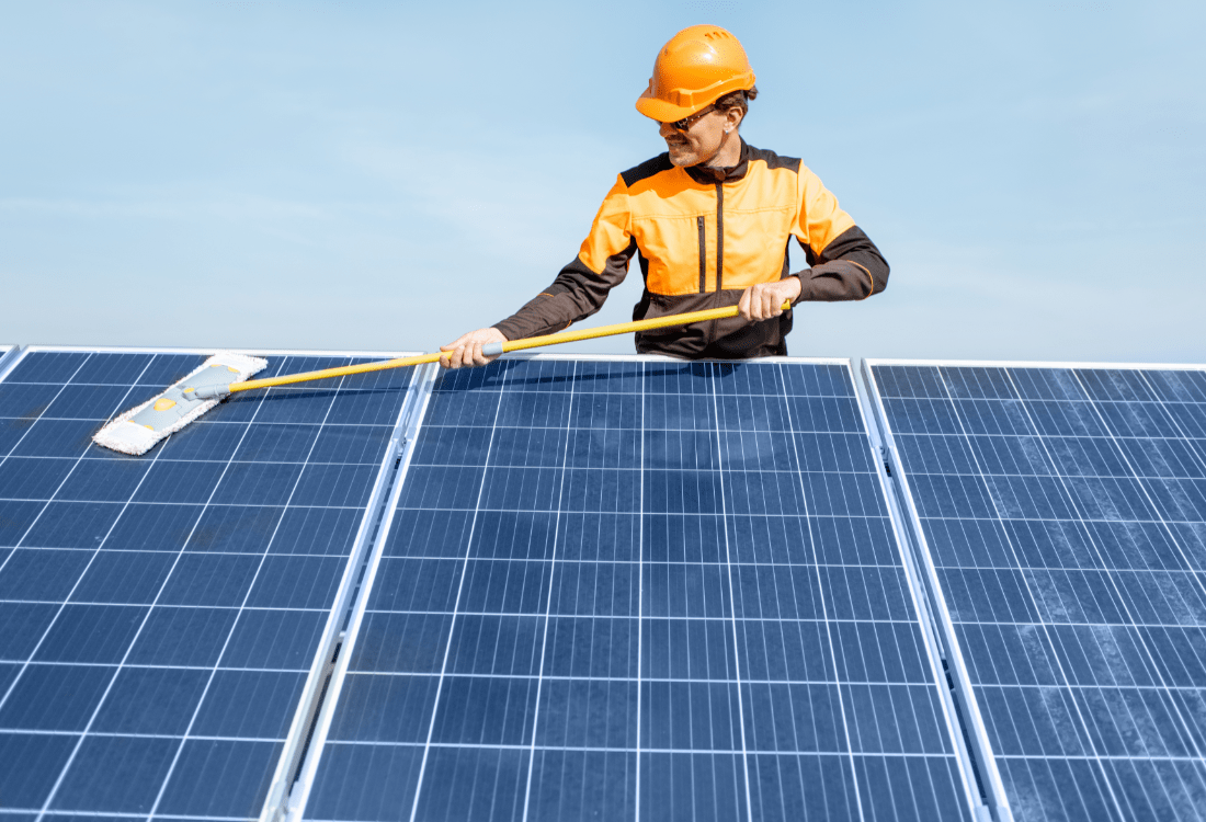 A man performing maintenance on his solar panels to ensure they’re successfully operating at peak efficiency.